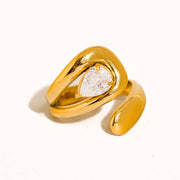 Gold ring with a pear-shaped diamond on a white background